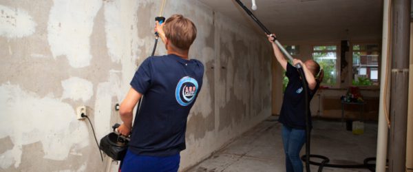 schoonmakers bezig desinfectie van muren
