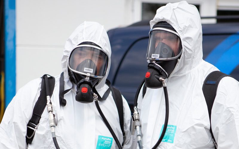 Ozonbehandeling uitvoeren waarbij de profs een masker dragen, bijvoorbeeld bij het ontruimen na overlijden